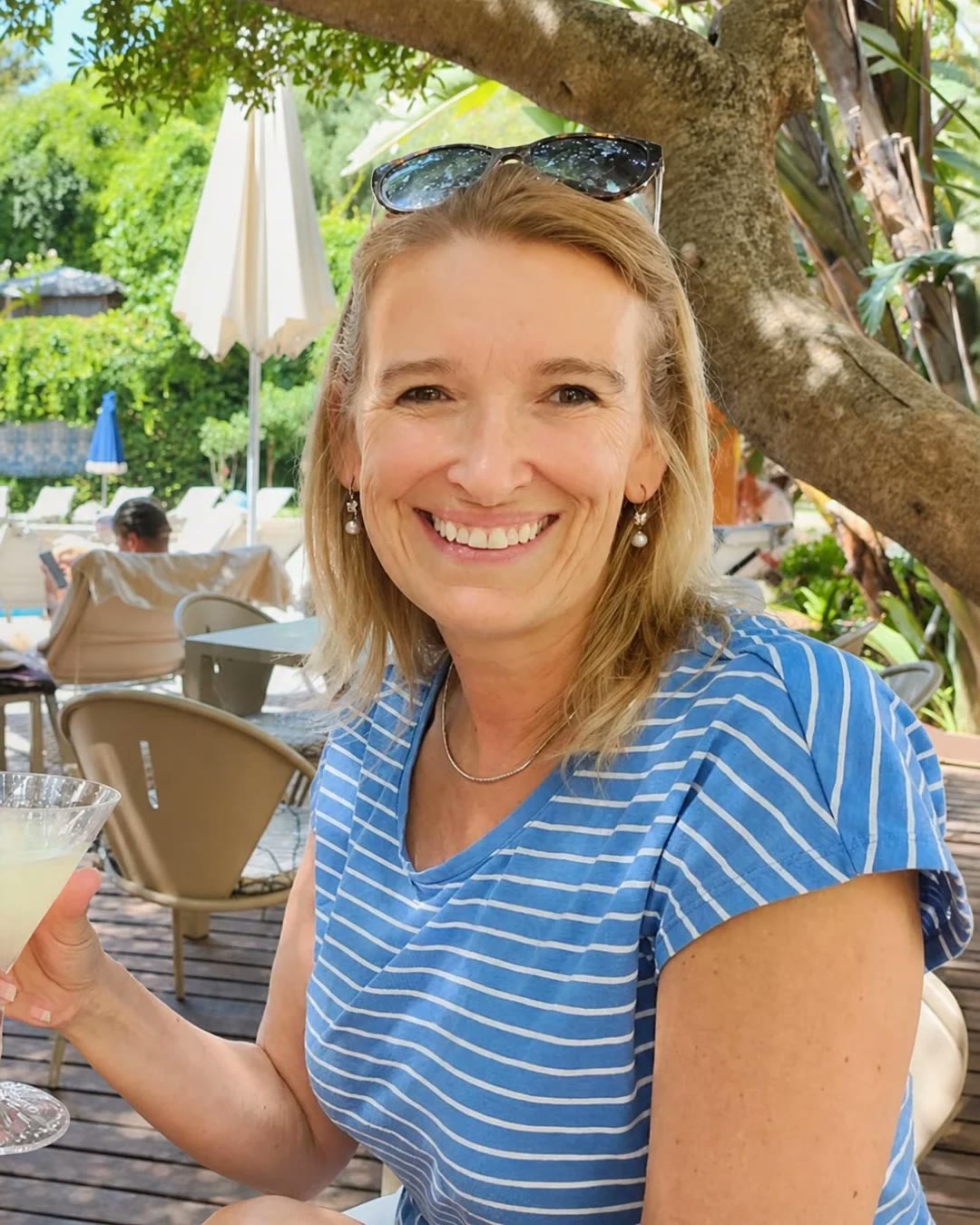 Sara Cromie smiling warmly at the camera in a sunny garden